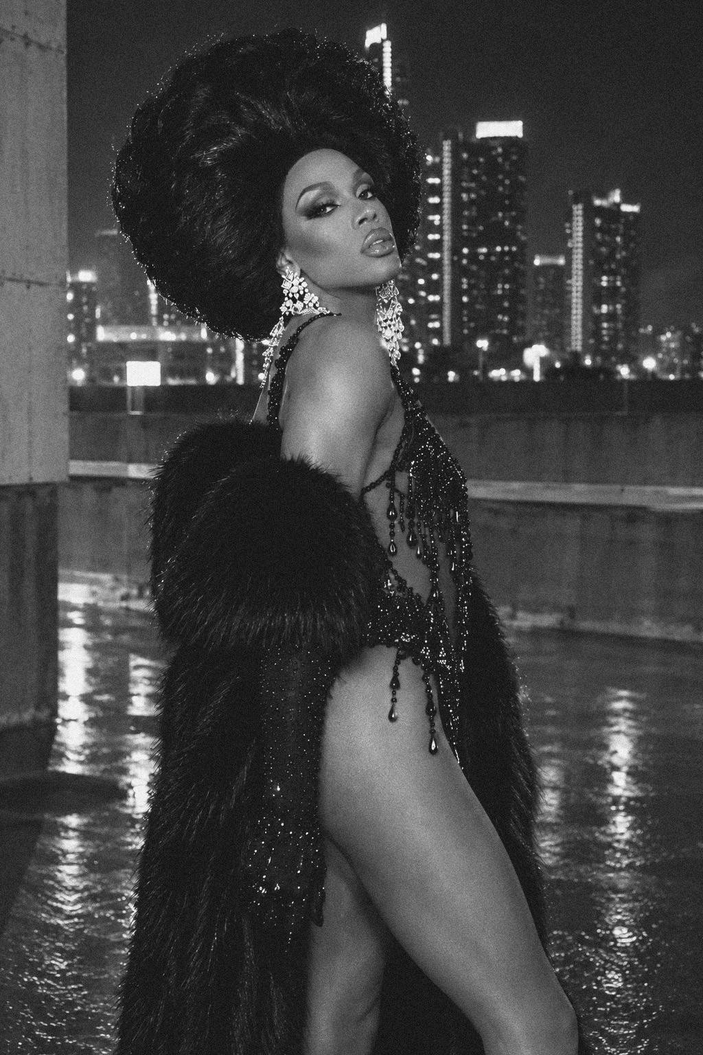Black-and-white rooftop portrait of Dee Jiles in a beaded look and fur